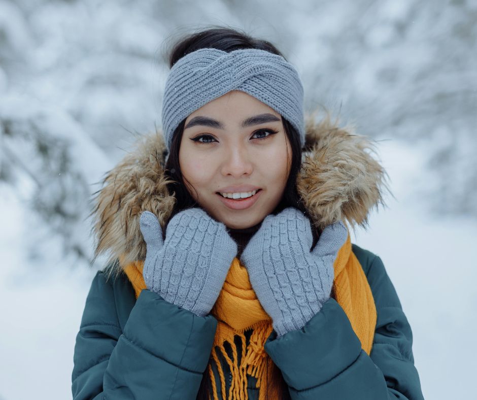 Multicultural woman smiling with healthy, glowing skin in winter, representing expert skincare tips from Skin By Duval.